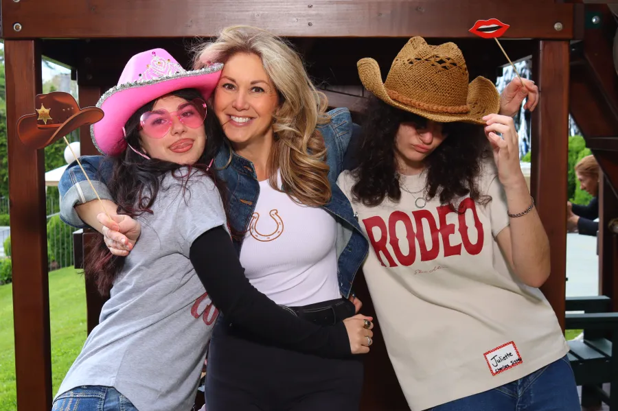 Guests in cowboy hats at the western-themed photo booth with a RODEO backdrop in Riverside, CT